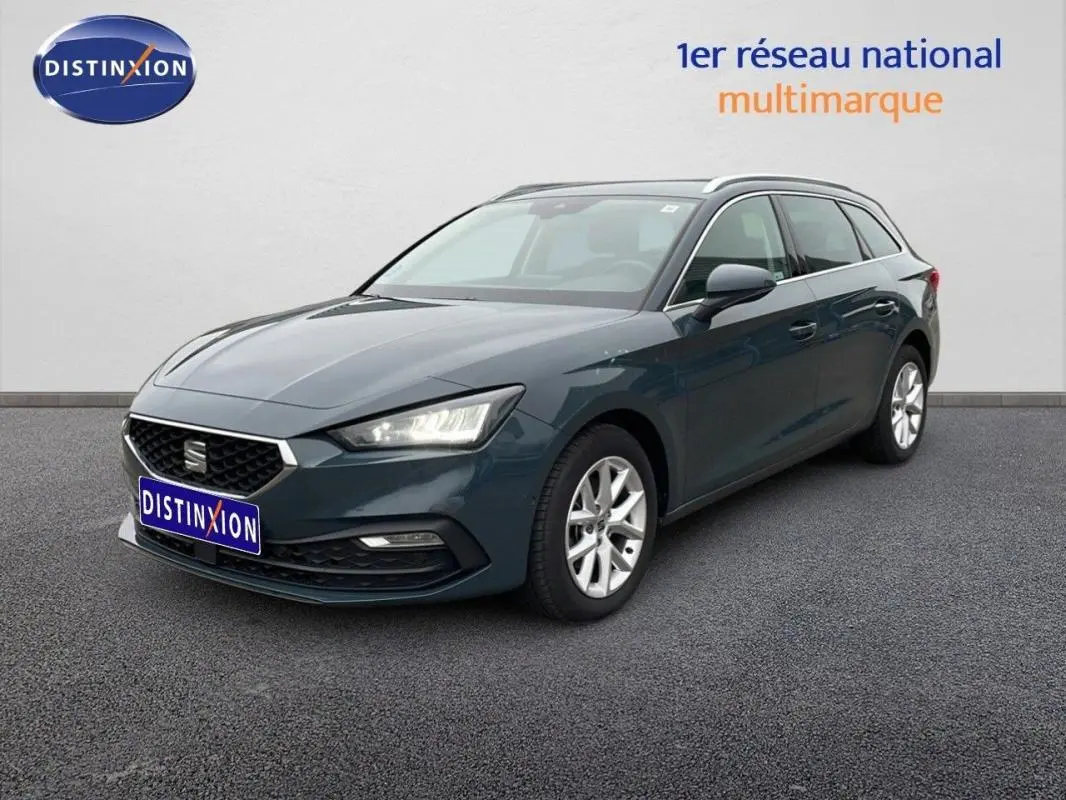 SEAT Leon ST bleu 3/4 avant droit avec barres de toit et jantes aluminium sur fond neutre.