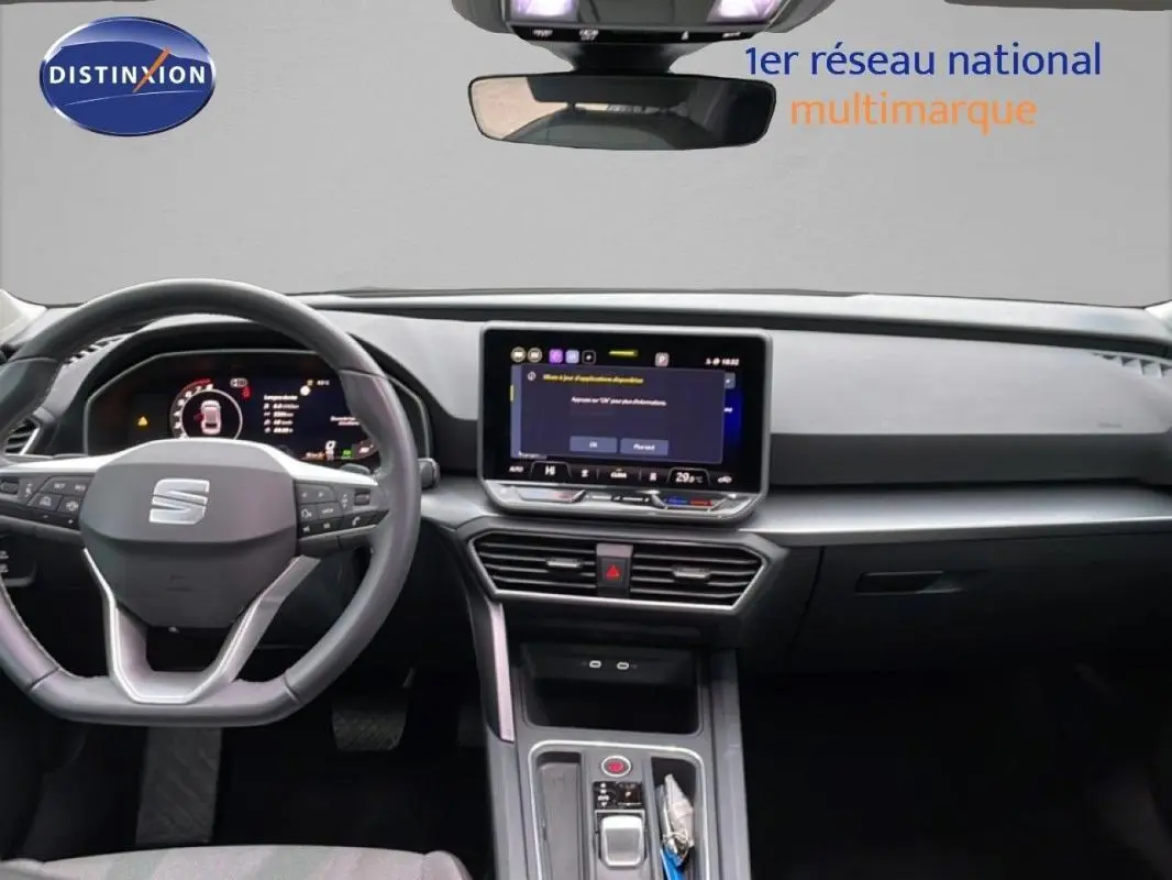 Vue intérieure frontale du tableau de bord et volant cuir du SEAT LEON ST IV 2025, avec écran tactile central allumé.