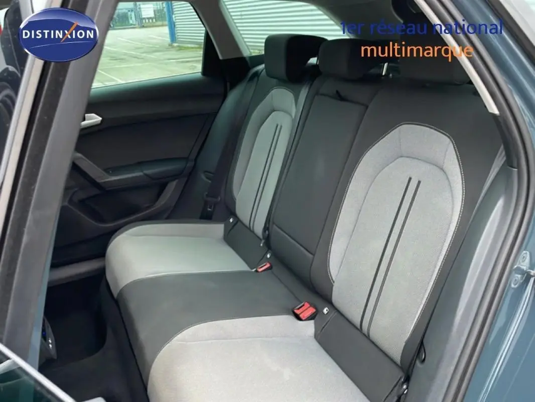 Vue intérieure montrant la banquette arrière bicolore gris clair et noir du SEAT Leon ST bleu, porte arrière ouverte côté droit.