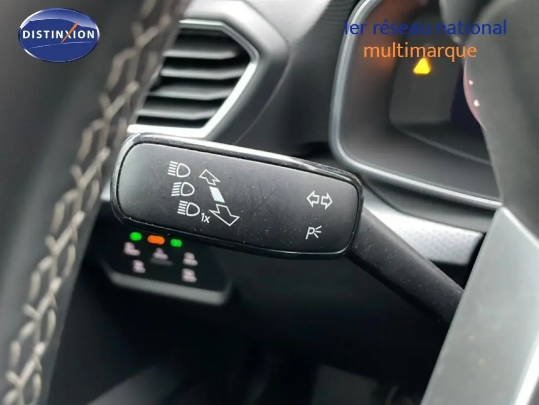 Gros plan sur la commande des feux et clignotants à gauche du volant dans l’habitacle du SEAT Leon ST bleu.