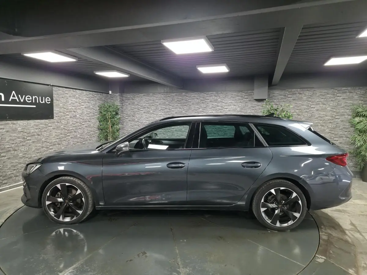 Profil droit d'une CUPRA Leon Sportstourer gris magnétique, avec jantes alliage noires et toit ouvrant panoramique.