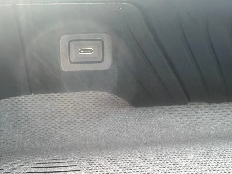 Gros plan sur une prise USB-C intégrée dans le coffre du Citroën C3 Aircross gris Mercury.