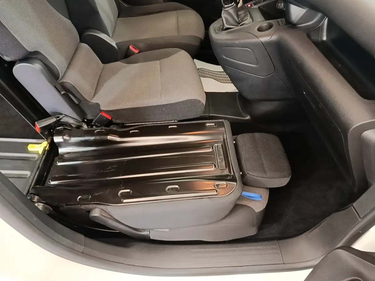 Vue intérieure côté droit du siège avant relevé du Citroën Berlingo blanc, montrant la structure métallique du siège.