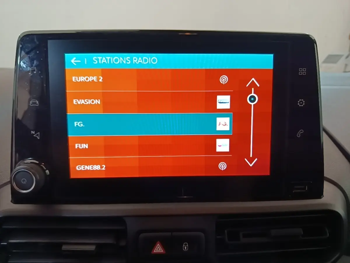 Écran tactile central de la Citroën Berlingo 2020 affichant la liste des stations radio en intérieur.