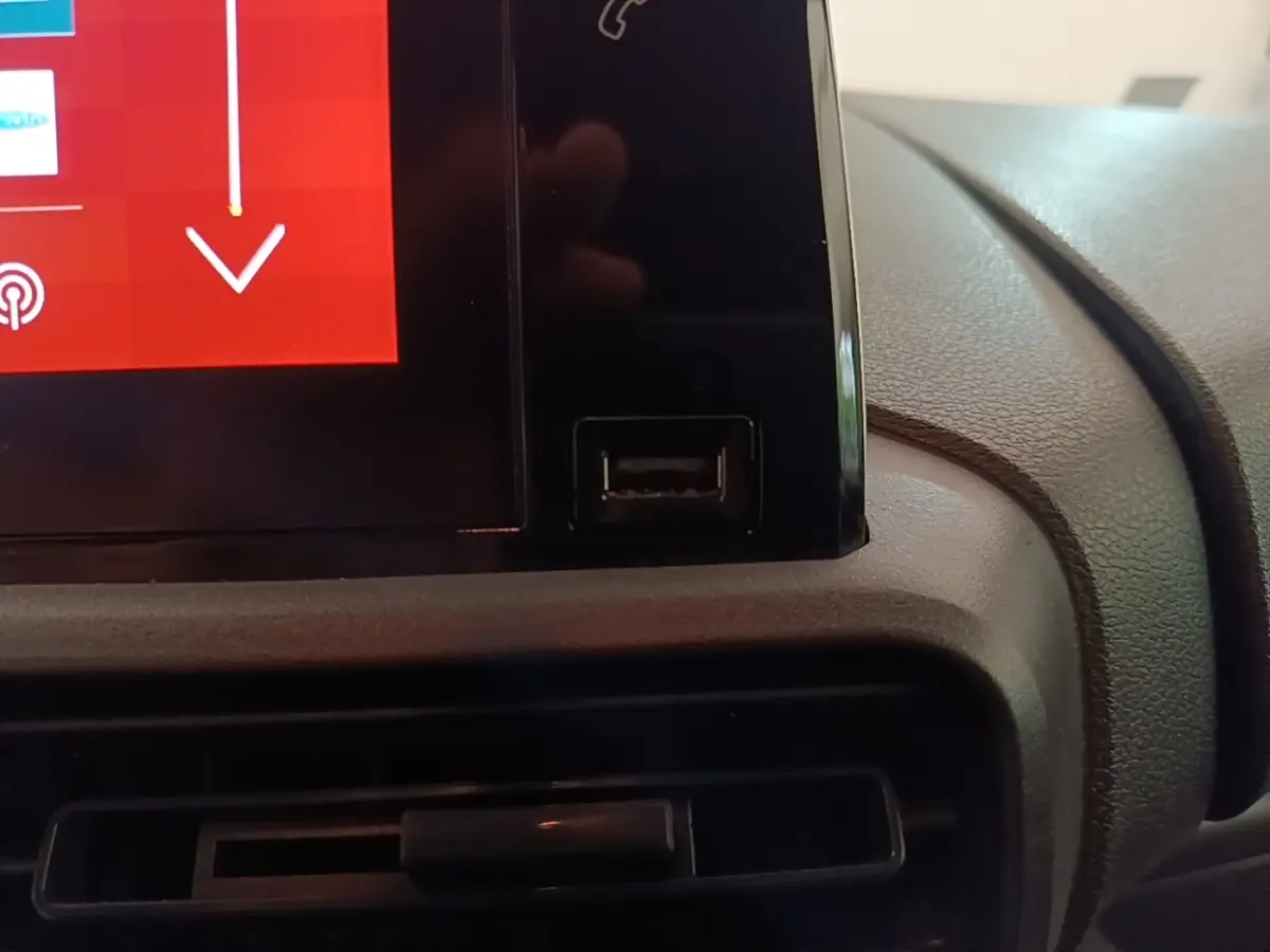 Gros plan sur l'écran tactile central noir et la prise USB du tableau de bord du Citroën Berlingo blanc de 2020.