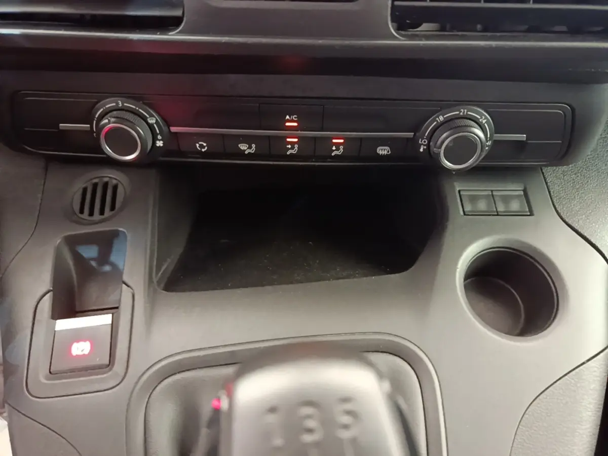 Vue rapprochée du tableau de bord noir du Citroën Berlingo 2020 avec commandes de climatisation et levier de vitesses manuel.