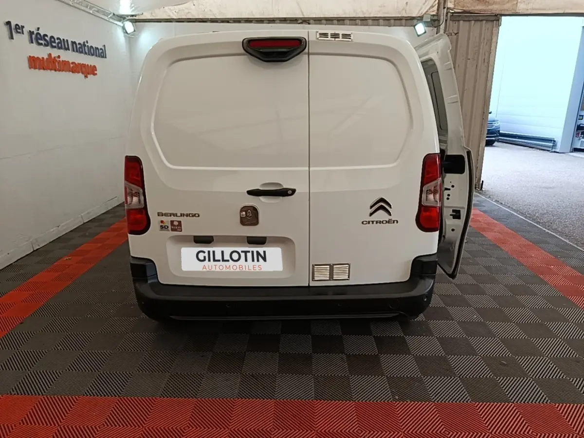 Vue arrière d’un Citroën Berlingo blanc 2020 avec porte arrière droite ouverte dans un garage.