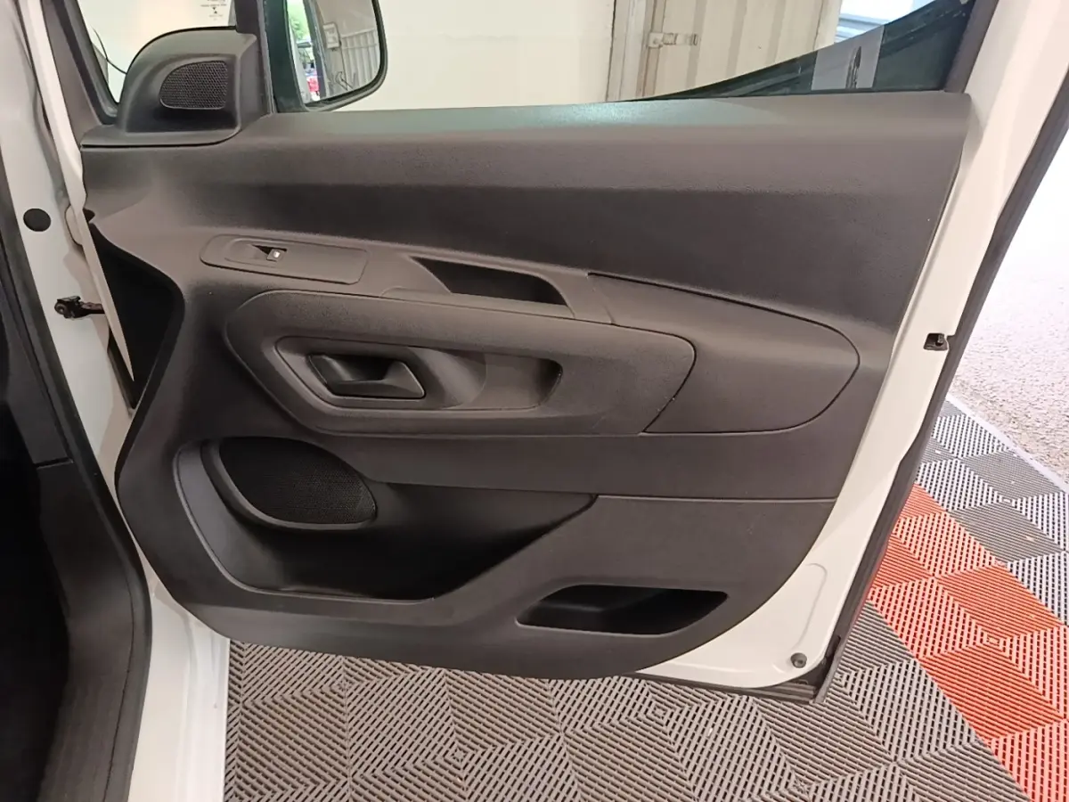 Vue rapprochée de la porte avant gauche blanche du Citroën Berlingo 2020 avec panneau intérieur noir.