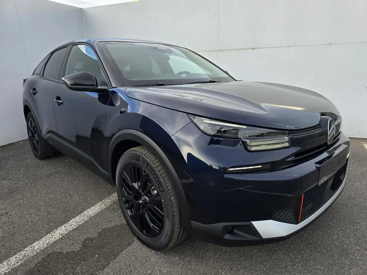 Citroën C4 III hybride bleu Eclipse avec toit noir, vue 3/4 avant mettant en valeur ses jantes noires et phares LED.