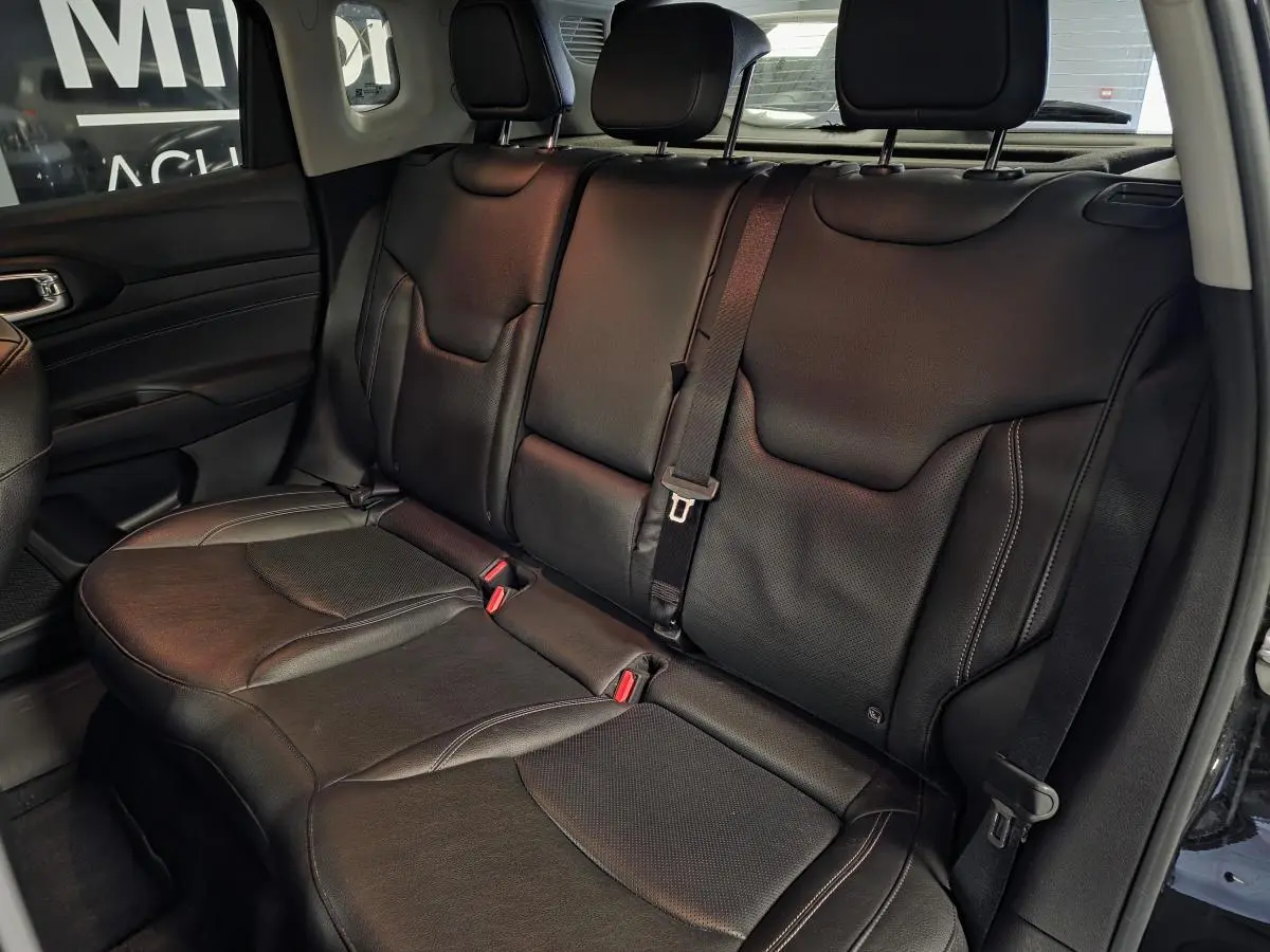 Vue latérale des sièges arrière en cuir noir du Jeep Compass 2022 avec ceinture de sécurité centrale visible