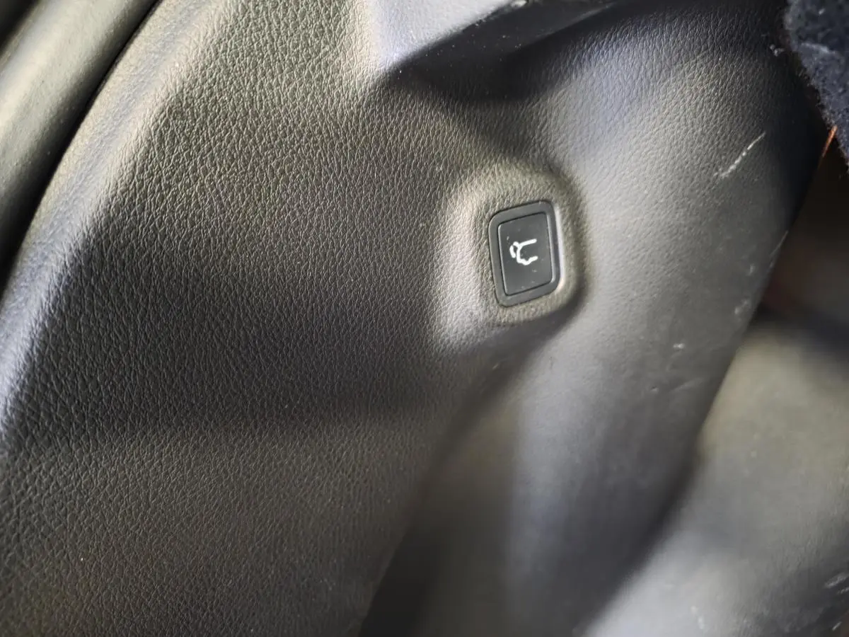 Bouton de déverrouillage du hayon sur panneau intérieur noir du coffre du Jeep Compass hybride rechargeable 2022.