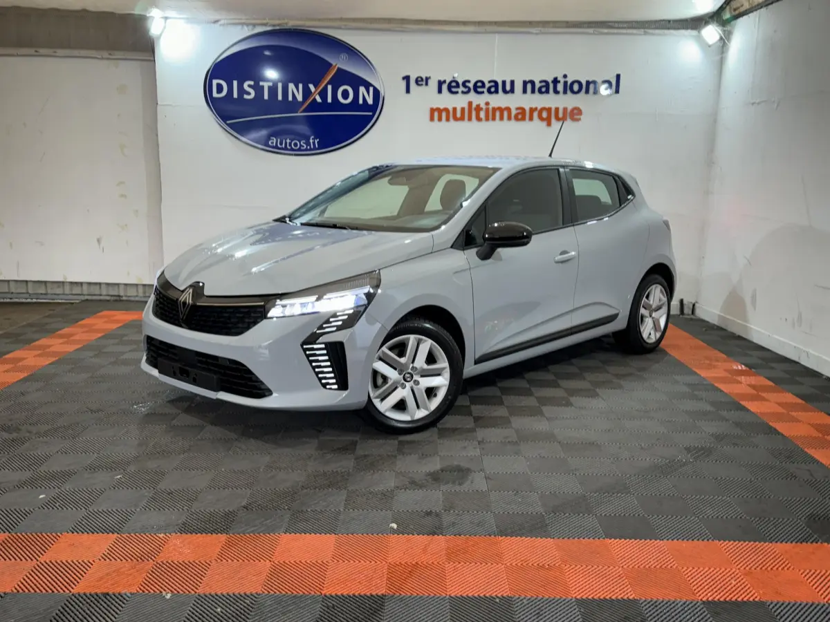 Renault Clio Evolution Blue dCi 100 gris clair vue 3/4 avant droit avec feux LED allumés dans un showroom