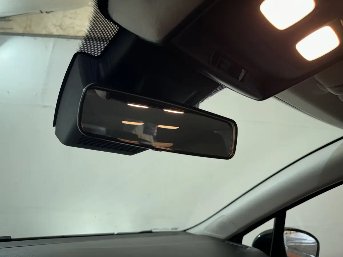 Rétroviseur intérieur et partie supérieure du pare-brise d'une Renault Clio gris clair vue de l'habitacle côté conducteur.