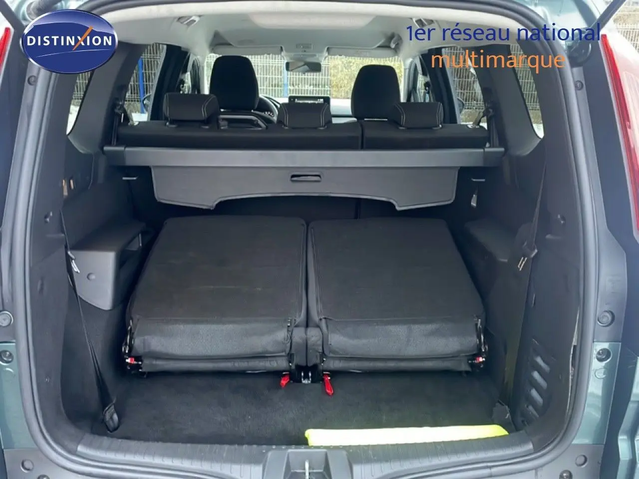 Vue arrière du Dacia Jogger vert cèdre métal avec banquette arrière rabattue et coffre ouvert.