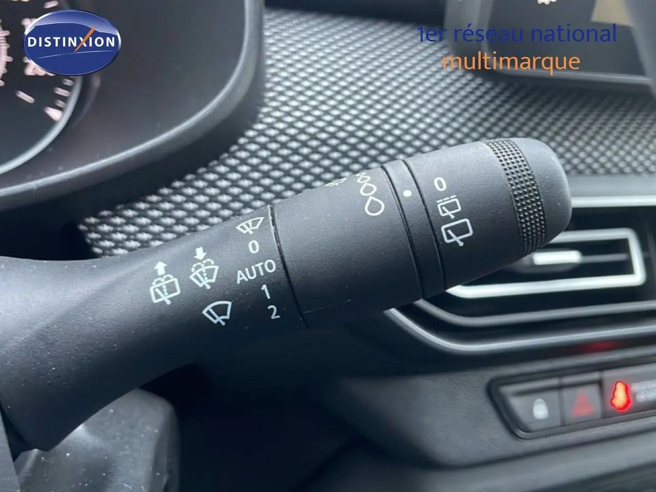 Gros plan sur la commande des essuie-glaces du tableau de bord d'une Dacia Jogger vert cèdre métal, intérieur noir.