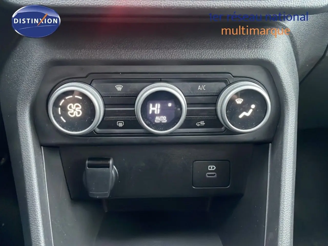 Gros plan sur la console centrale noire du Dacia Jogger 2025, montrant les commandes de climatisation circulaires.