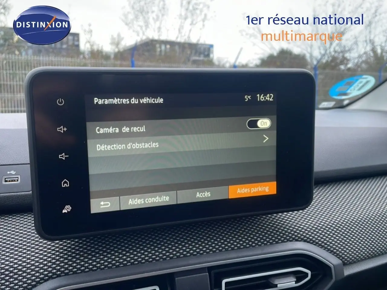 Écran tactile central du tableau de bord du Dacia Jogger affichant les paramètres de caméra de recul et détection d'obstacles.