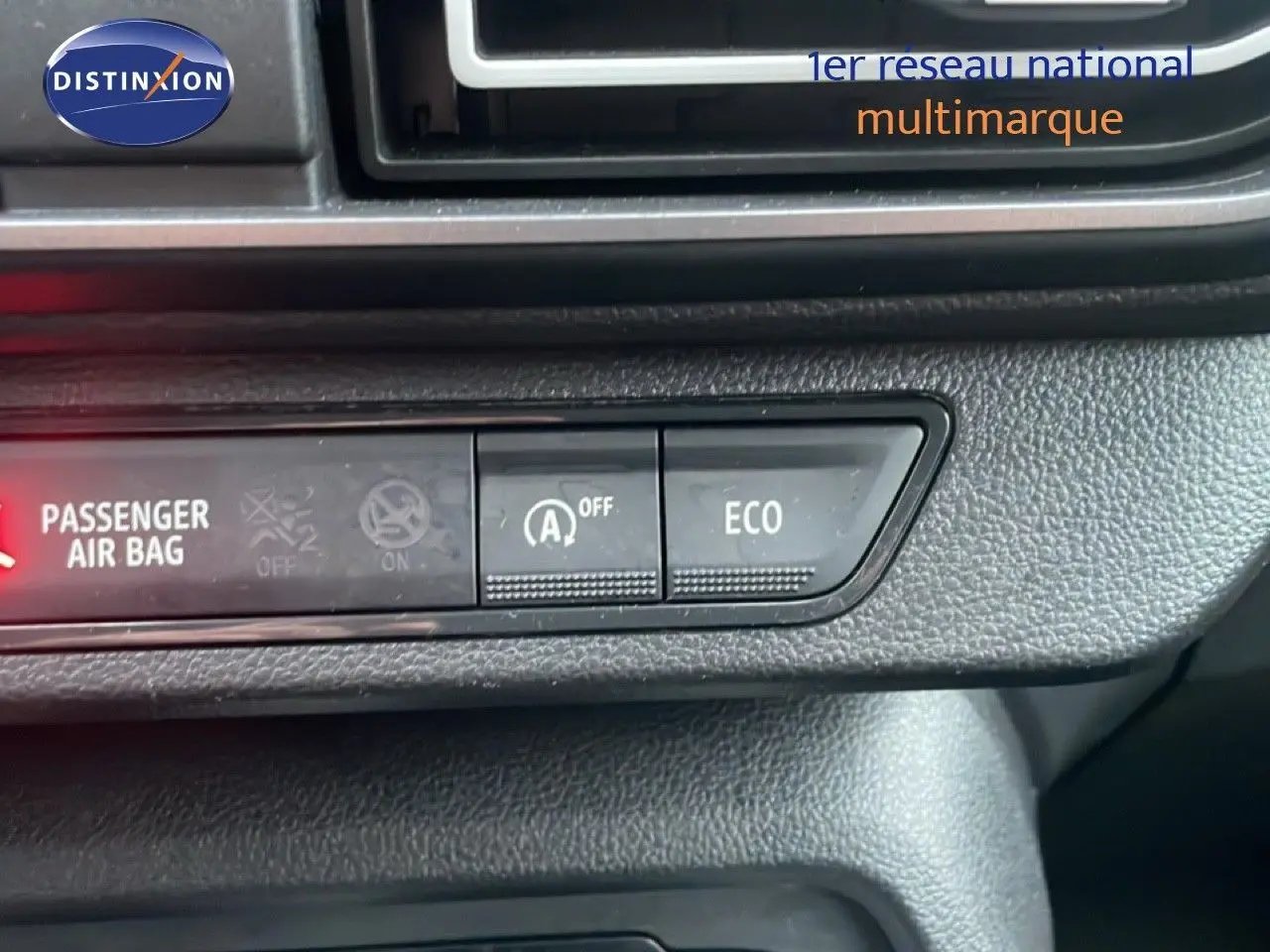 Gros plan sur les commandes du tableau de bord du Dacia Jogger, avec bouton ECO et témoin airbag passager allumé.