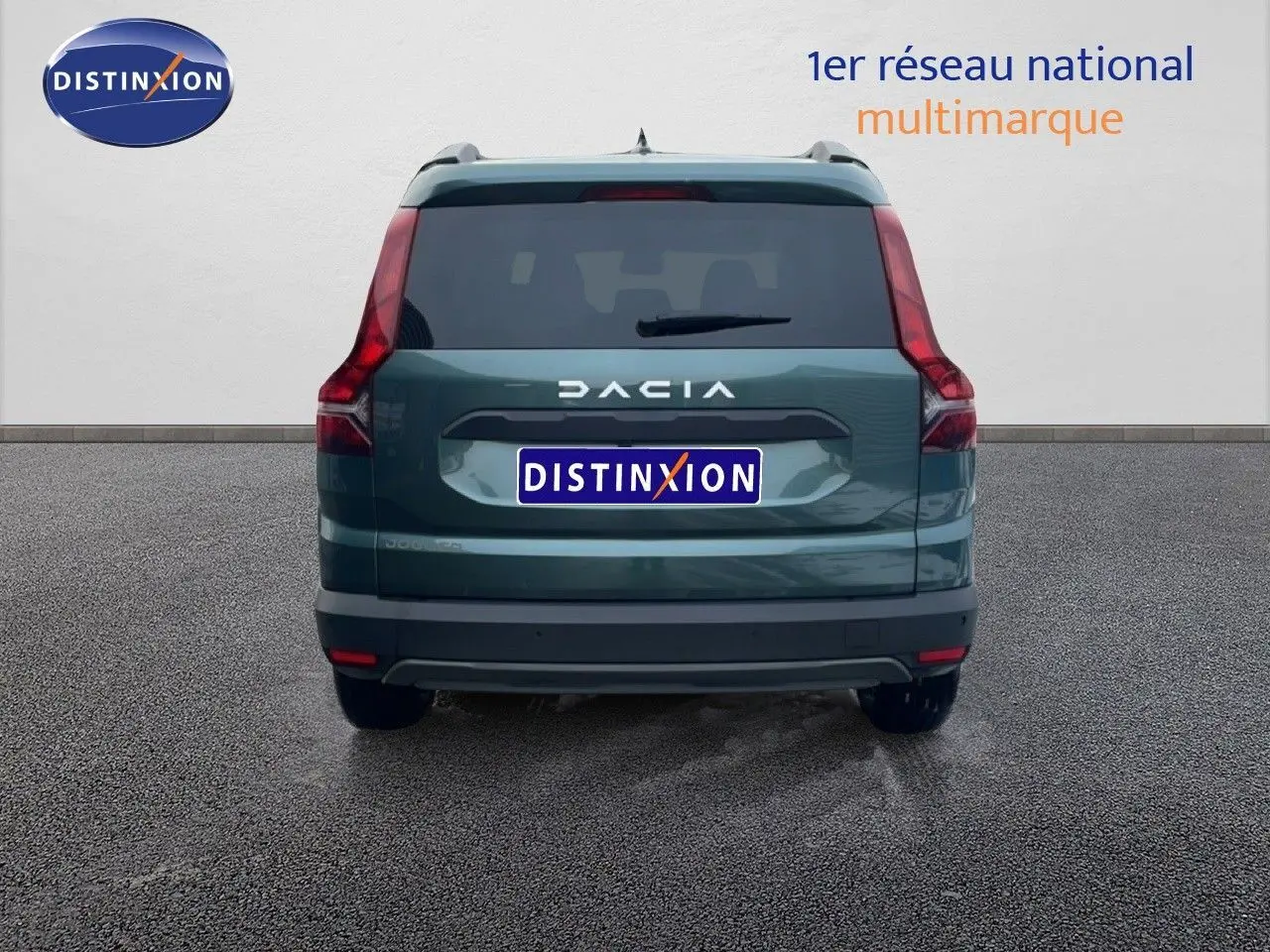 Vue arrière d'un Dacia Jogger vert cèdre métal avec feux LED et logo DACIA bien visibles.