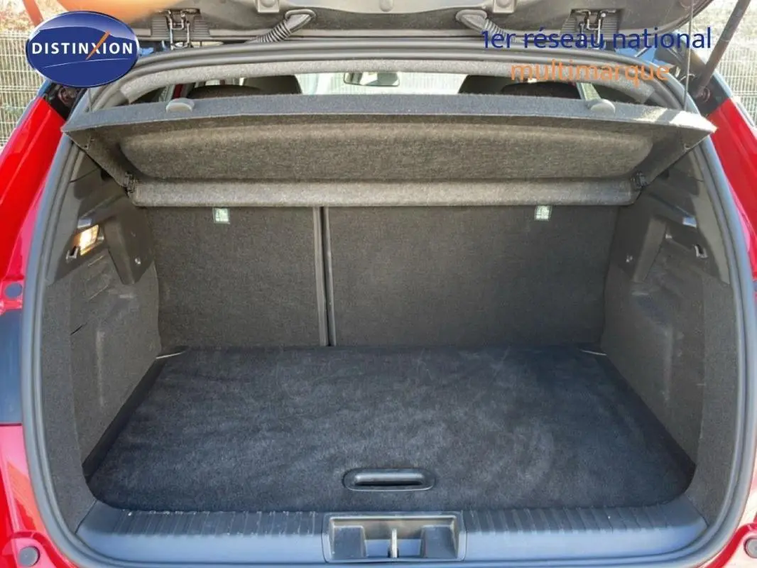 Coffre ouvert d'un Renault Captur rouge 2025, vue arrière montrant l'espace de chargement vide et la tablette cache-bagages.