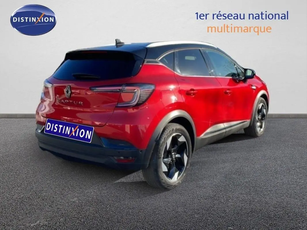 Vue 3/4 arrière droite d'un Renault Captur rouge avec toit noir et jantes aluminium noires.