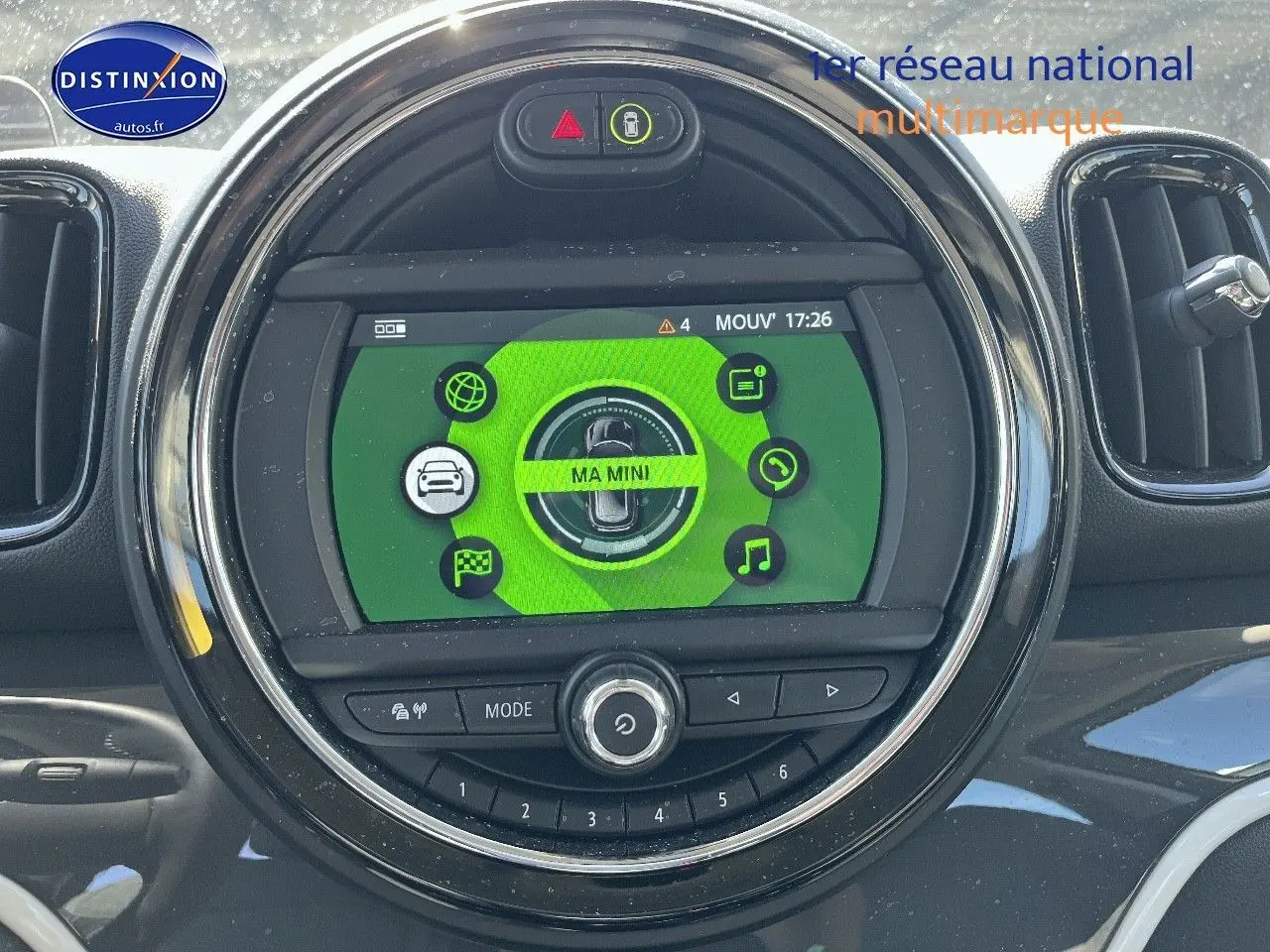 Vue rapprochée du tableau de bord de la MINI Countryman Moonwalk Grey, écran central rond avec interface verte et commandes intégrées.