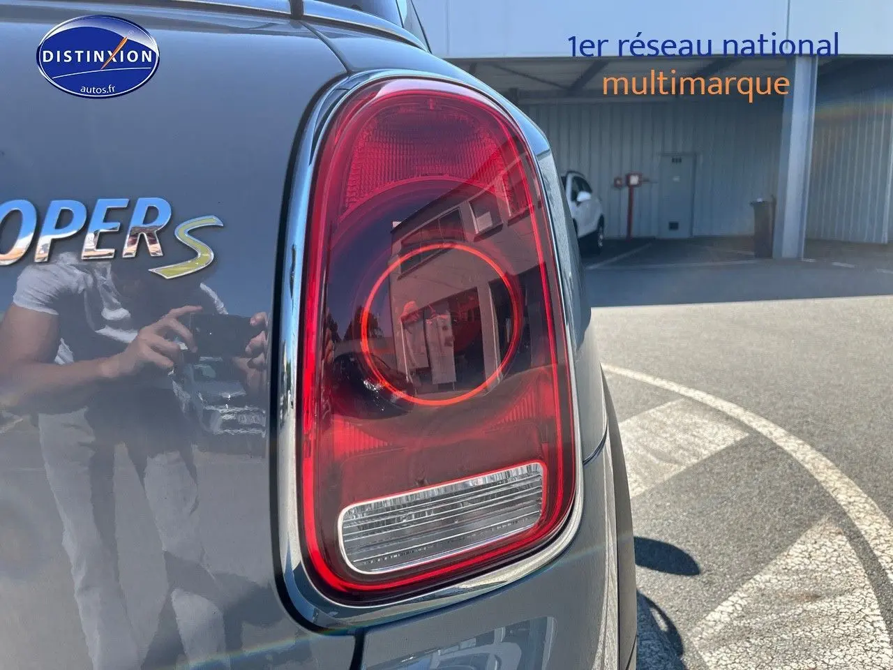 Gros plan sur le feu arrière droit d’une MINI Countryman Cooper S Moonwalk Grey avec reflet du photographe.