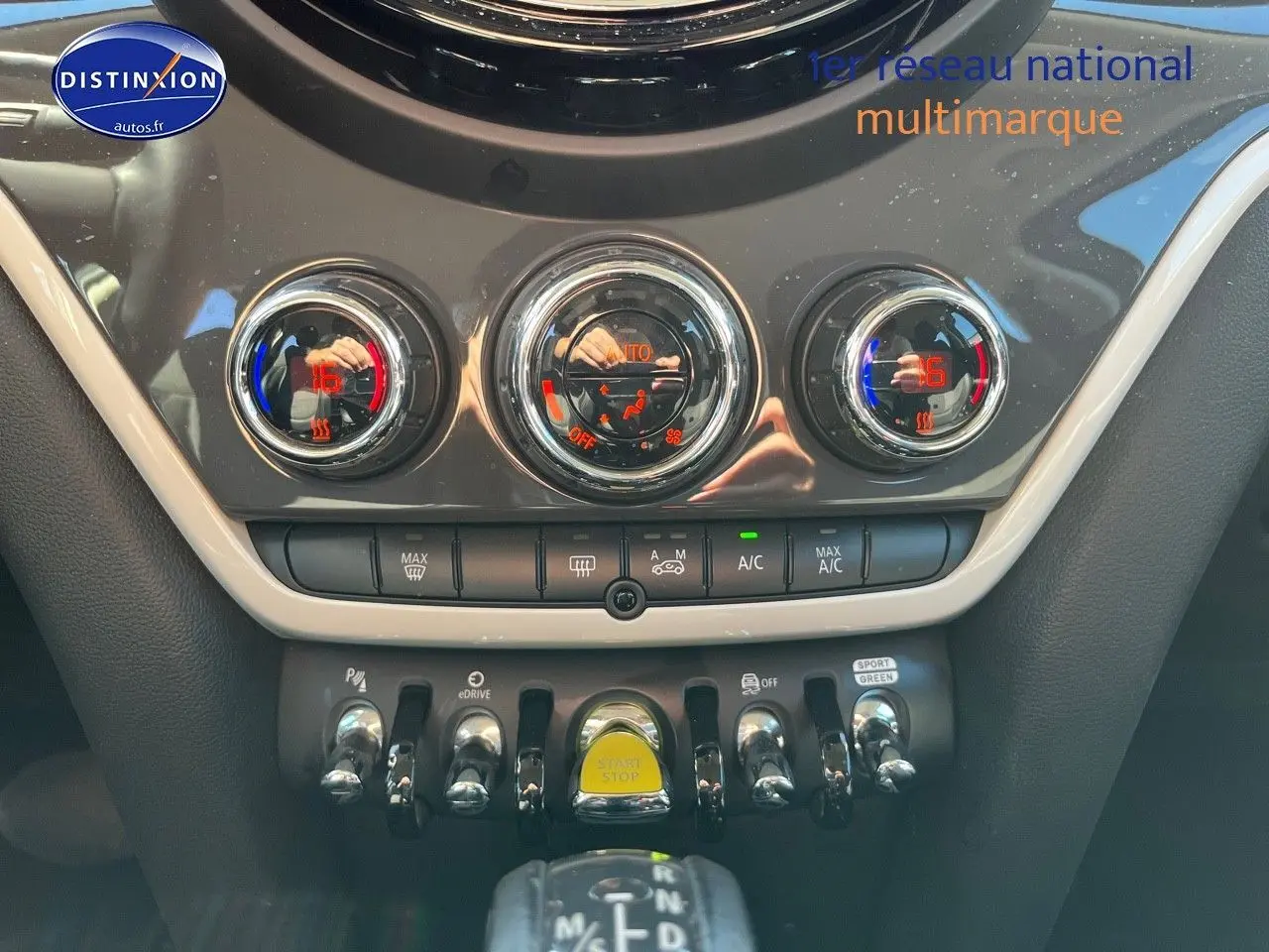 Vue rapprochée de la console centrale du MINI Countryman Moonwalk Grey, avec commandes clim et bouton Start/Stop jaune.