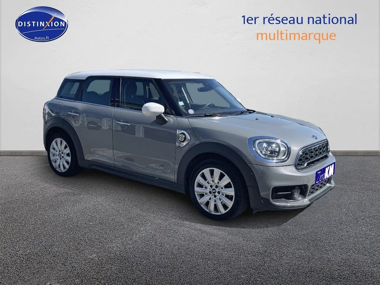 Vue 3/4 avant droite d'une MINI Countryman hybride Moonwalk Grey avec toit et rétroviseurs blancs.