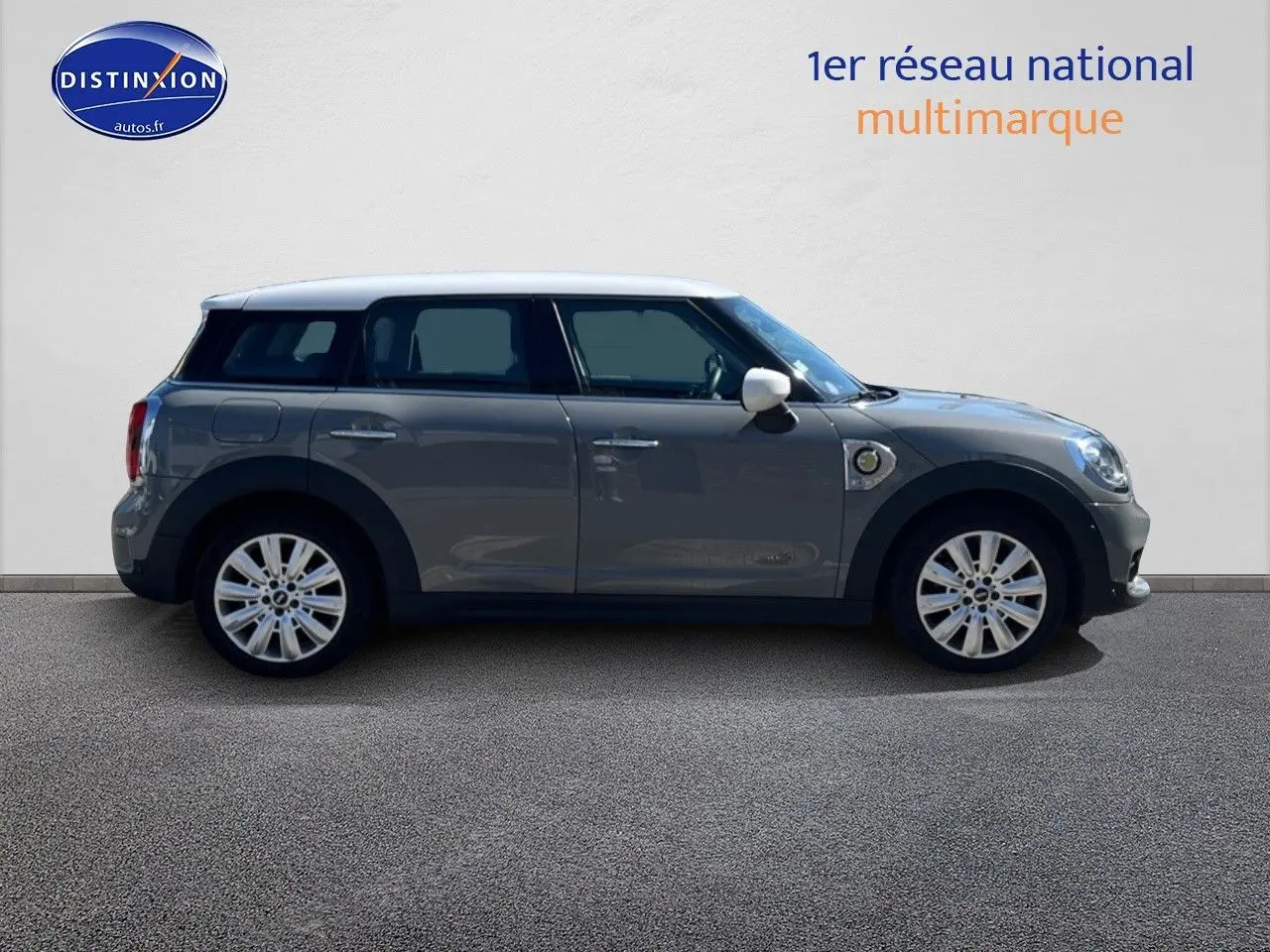 Profil droit d'une MINI Countryman hybride rechargeable Moonwalk Grey avec toit et rétroviseurs blancs, jantes alu 18 pouces.