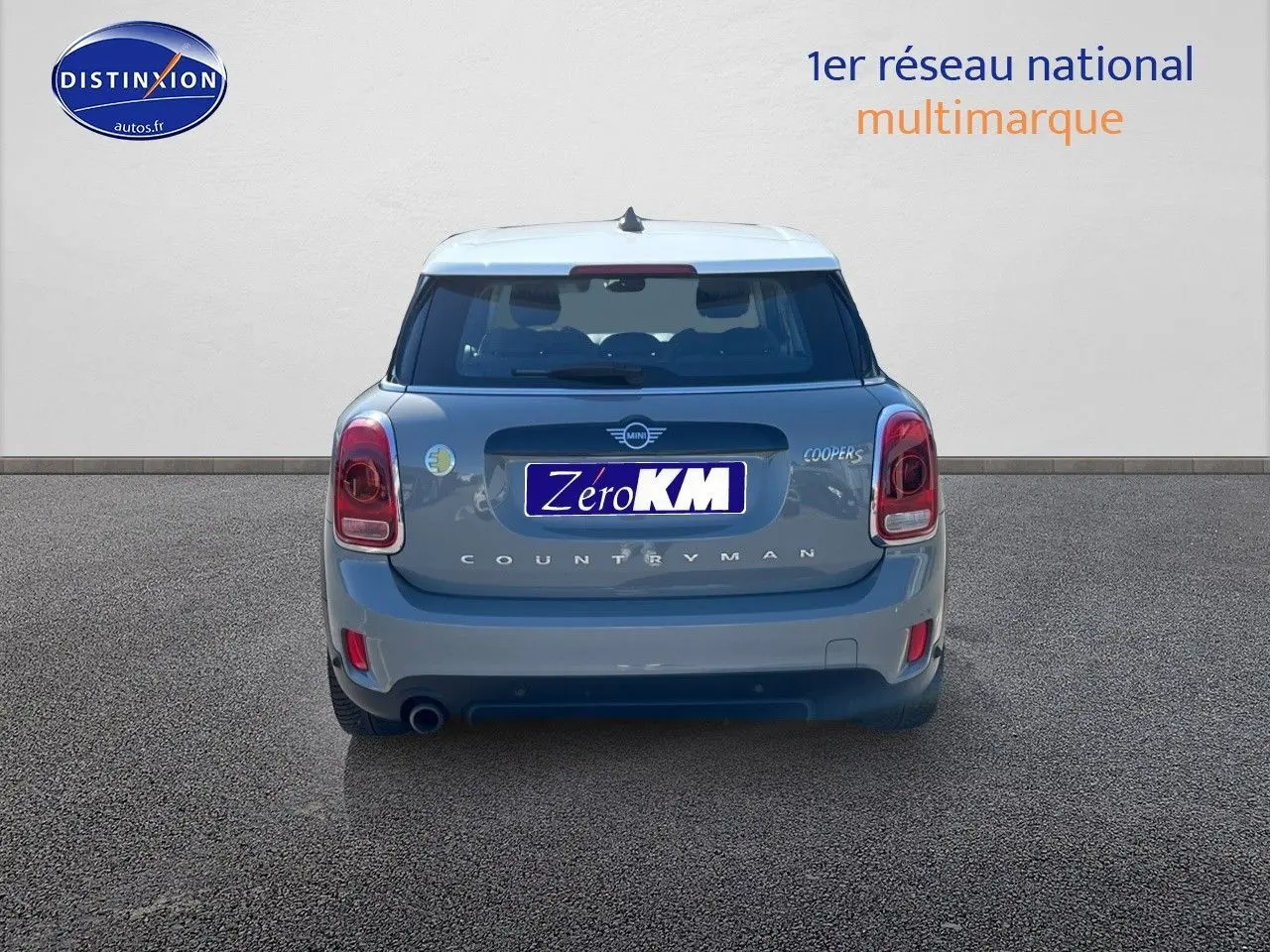 Vue arrière d'une MINI Countryman Cooper SE Moonwalk Grey avec toit blanc sur fond neutre.