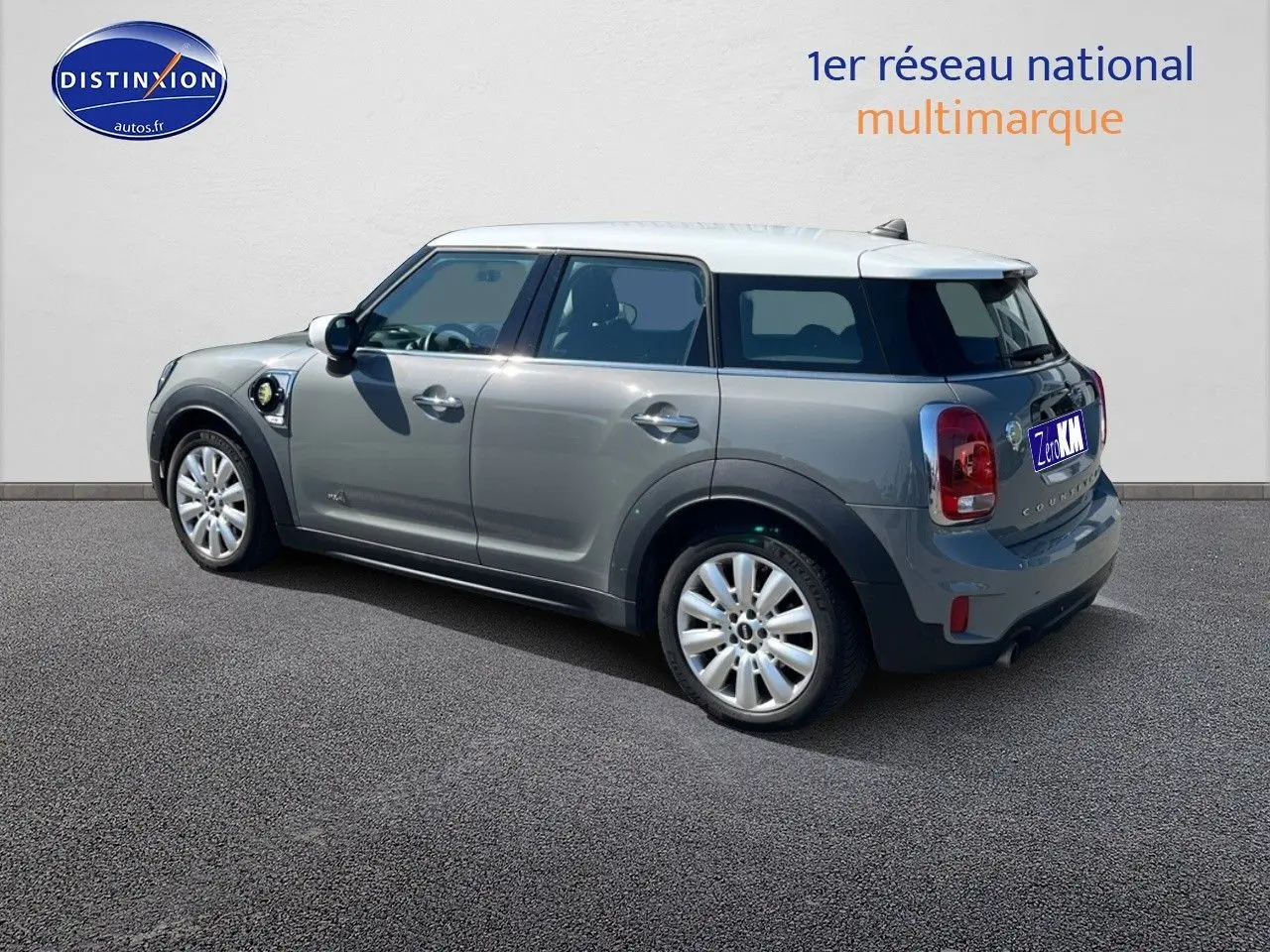 Vue 3/4 arrière droite d'une MINI Countryman Cooper SE hybride rechargeable Moonwalk Grey avec toit blanc et jantes 18 pouces.
