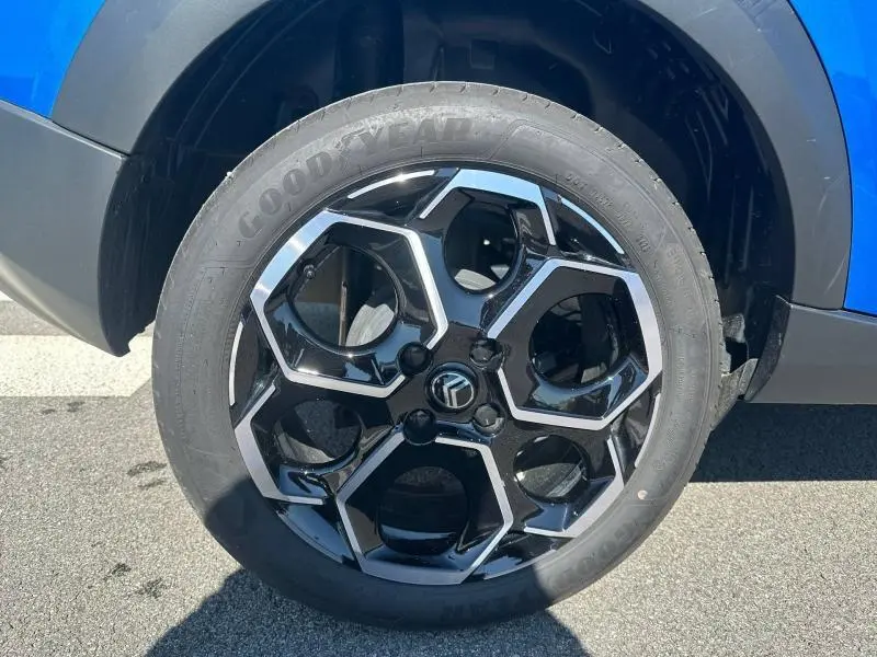 Gros plan sur la roue avant gauche d’une Citroën C3 2025 noire, jante alliage noire et argentée au design hexagonal.