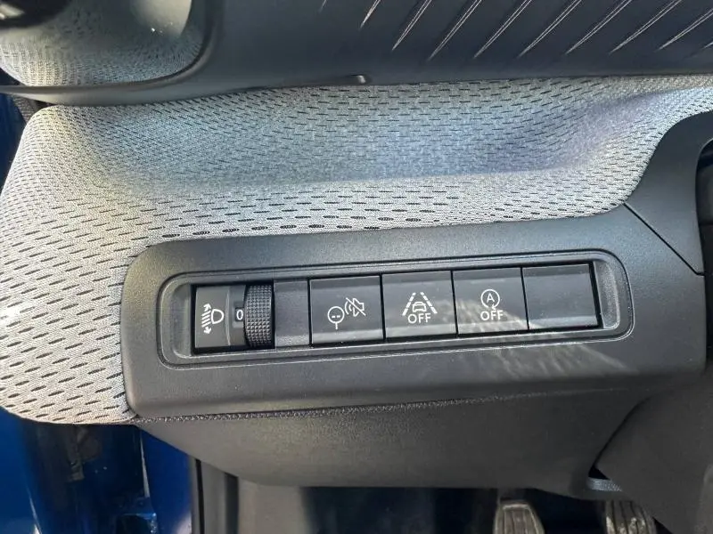 Gros plan sur les commandes de bord de la Citroën C3 1.2 Turbo 100ch MAX 2025, avec boutons de réglage et désactivation d’aides.