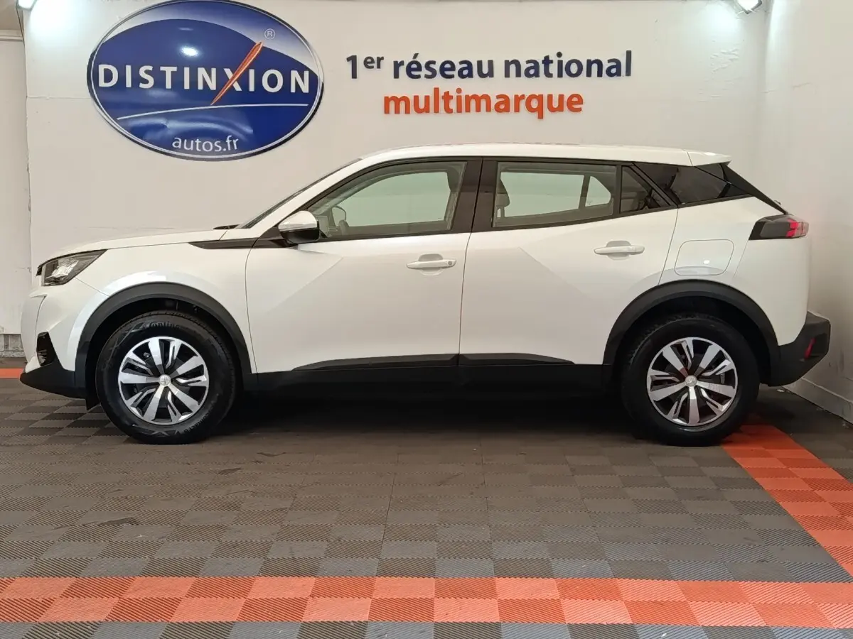 Peugeot 2008 blanc vue de profil côté gauche, SUV compact avec jantes alliage et toit noir contrasté.