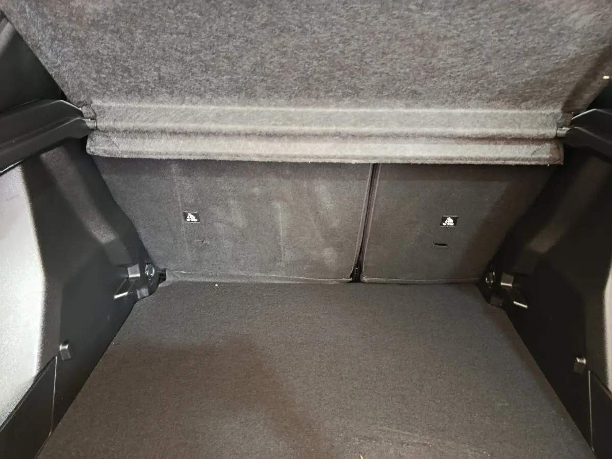 Coffre ouvert de Peugeot 2008 blanc, vue intérieure montrant la banquette arrière rabattue et le plancher plat.