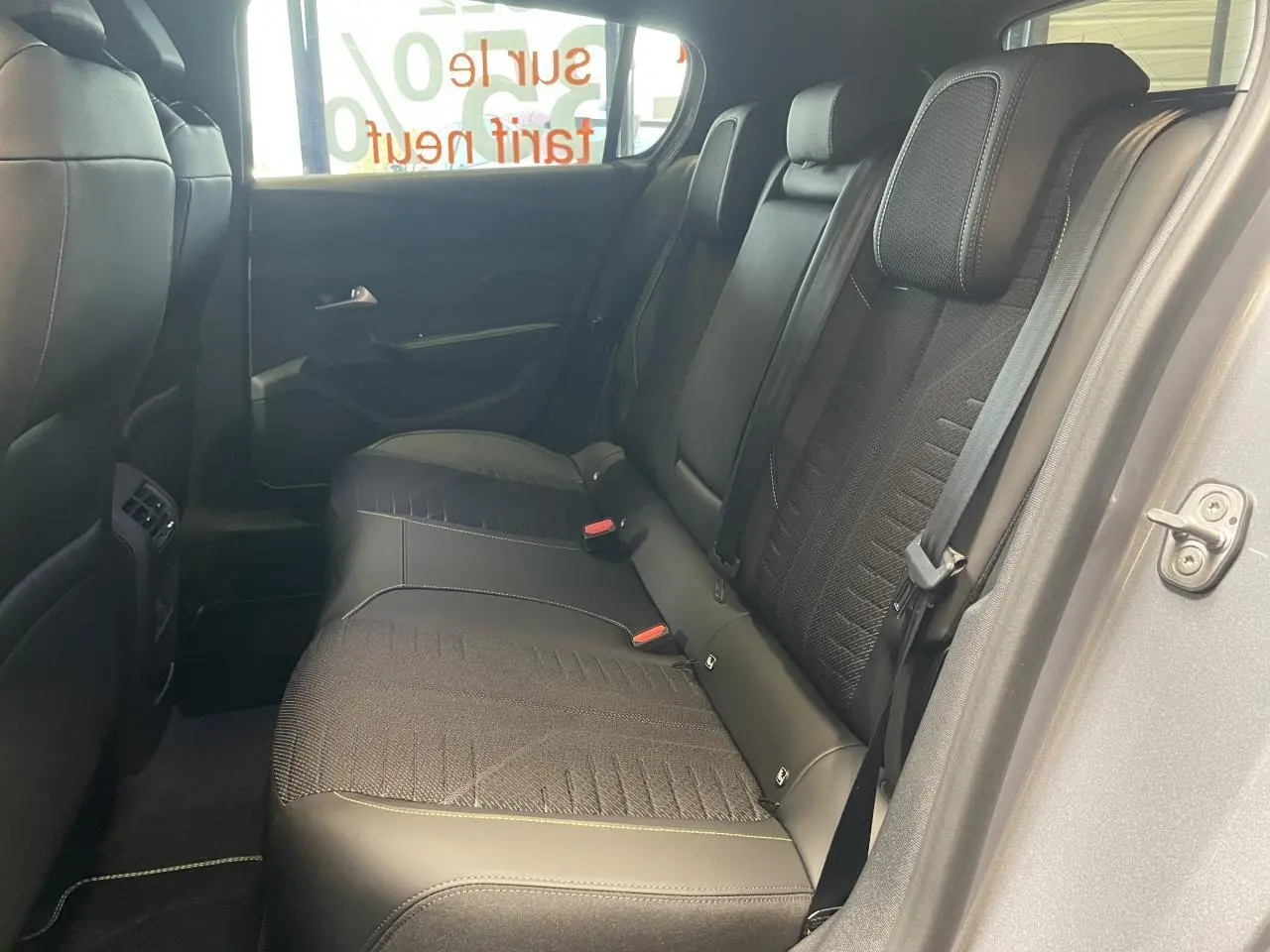Vue côté droit de la banquette arrière noire de la Peugeot 308 GT 2026 avec surpiqûres vert Adamite et ceinture de sécurité.
