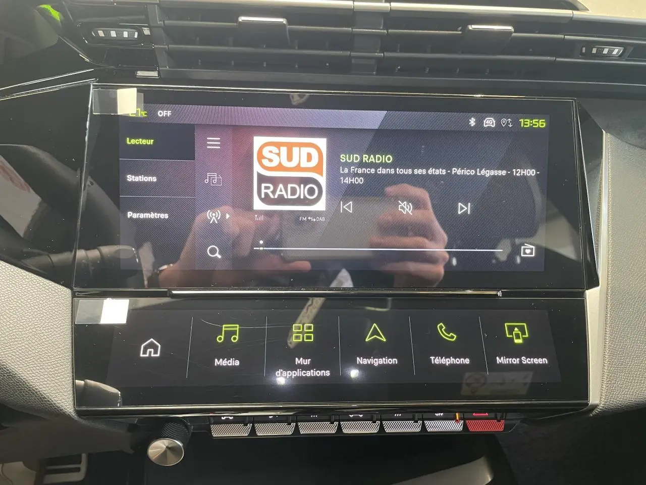 Écran tactile central du Peugeot 308 gris Artense, affichant la radio Sud Radio en intérieur noir et gris.