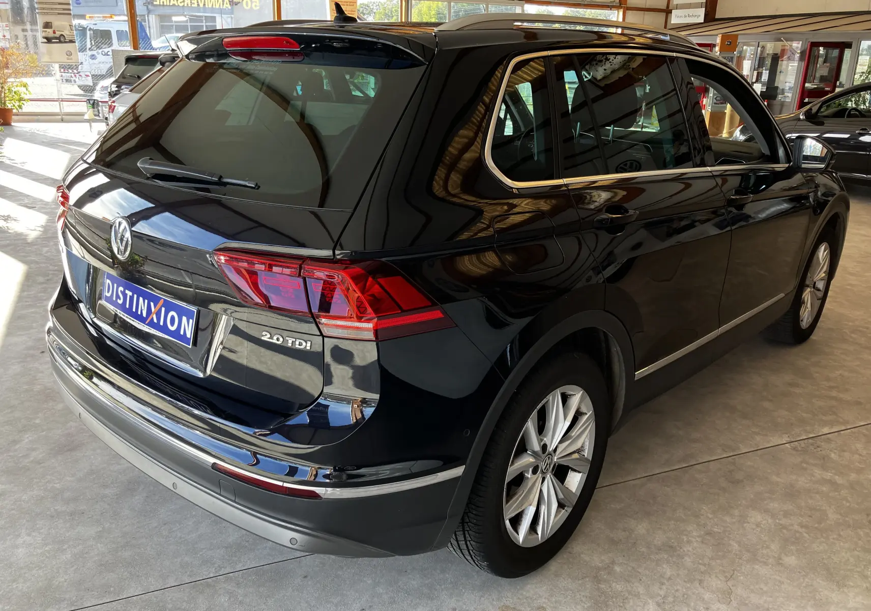 Vue 3/4 arrière droite d'un Volkswagen Tiguan noir 2.0 TDI 150 DSG avec jantes alliage et badge distinctif 2.0 TDI.