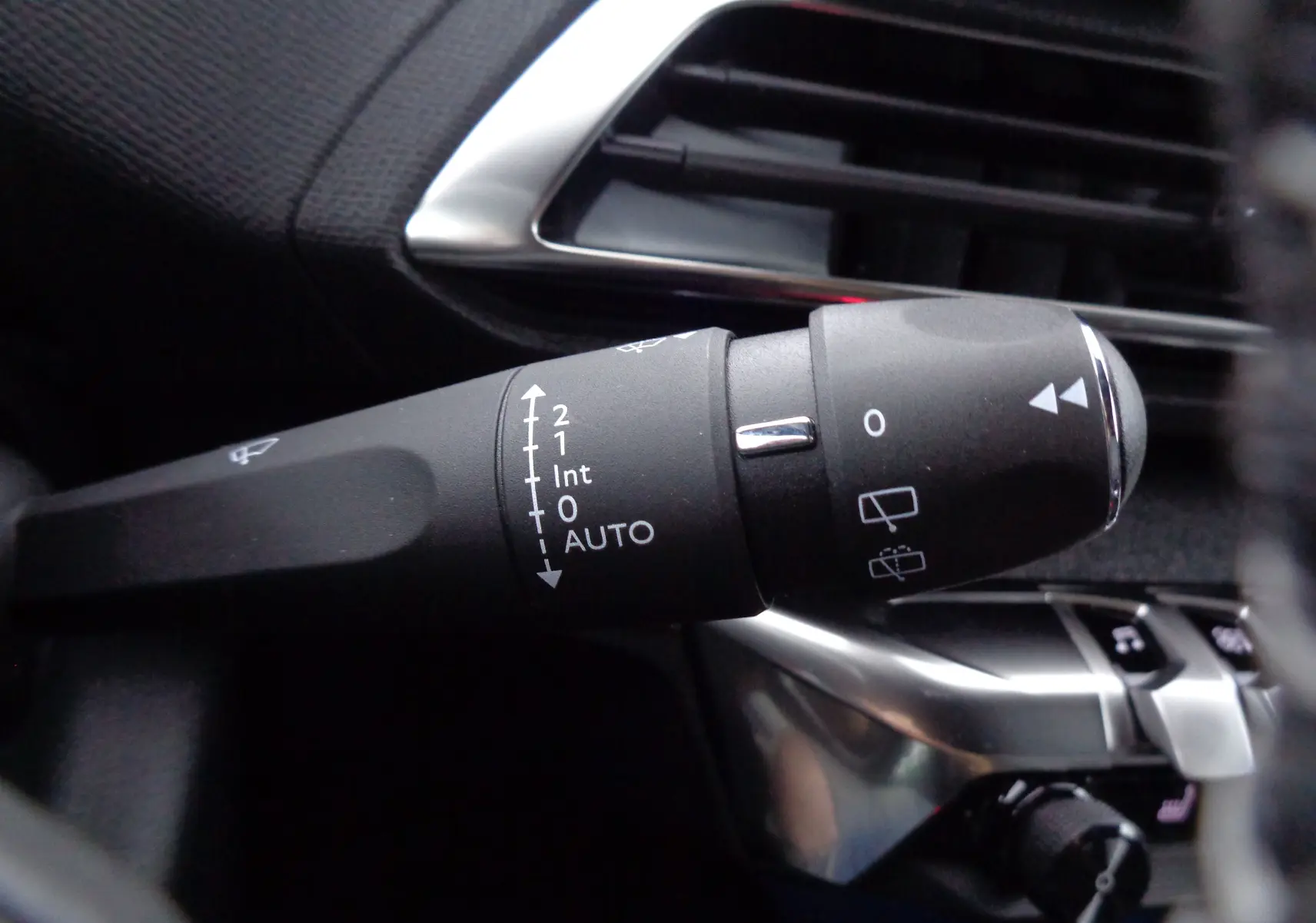 Gros plan sur la commande des essuie-glaces dans l'habitacle du Peugeot 5008 gris platinium 2023.