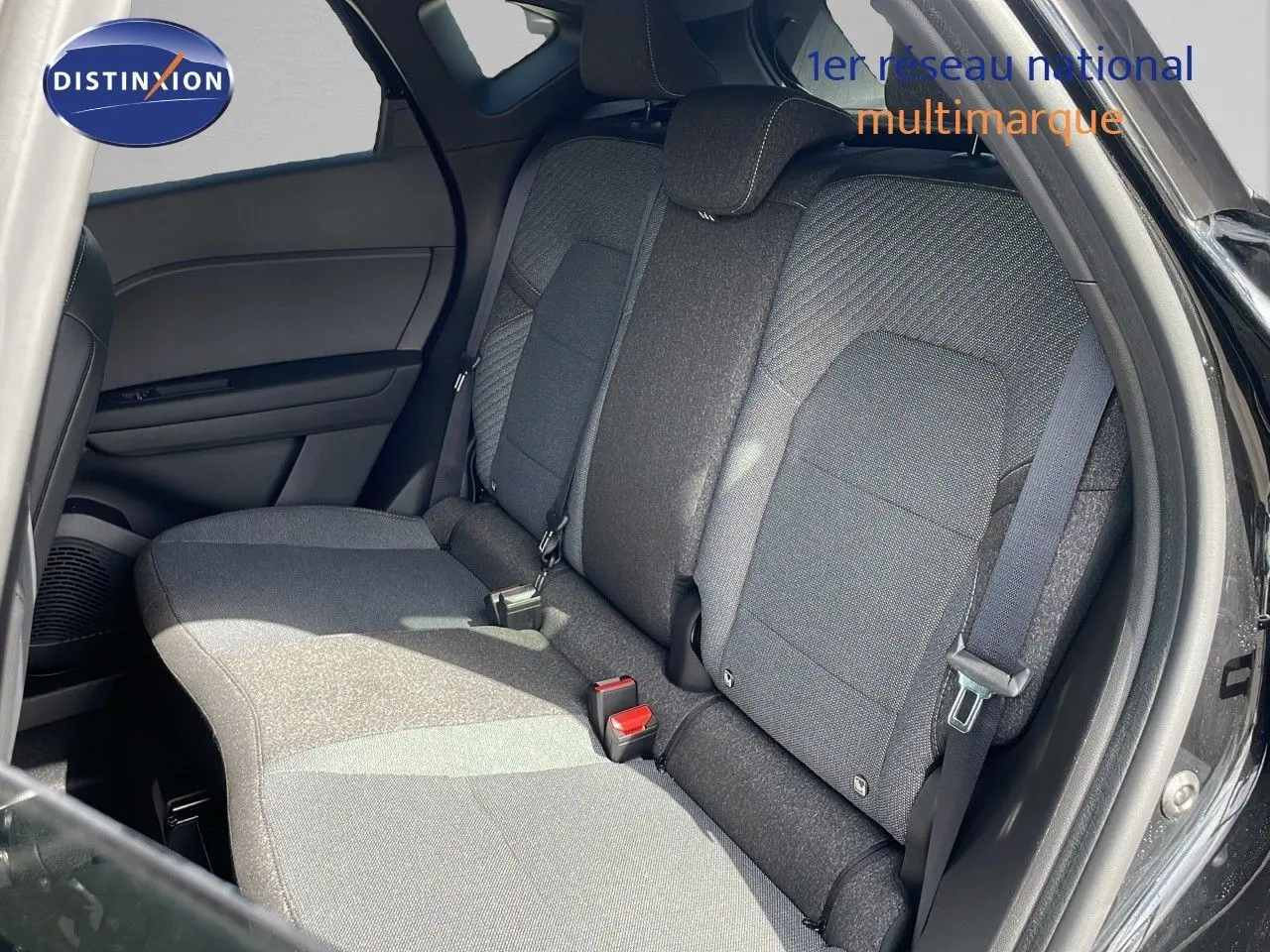 Vue intérieure sur les sièges arrière en tissu gris foncé du Renault Captur 2025 avec portières ouvertes côté droit.