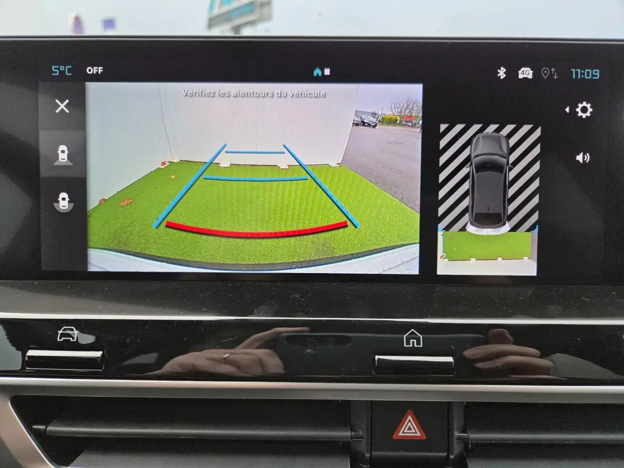 Écran de caméra de recul affichant l'aide au stationnement du Citroën C4 blanc avec toit noir, vue arrière virtuelle.