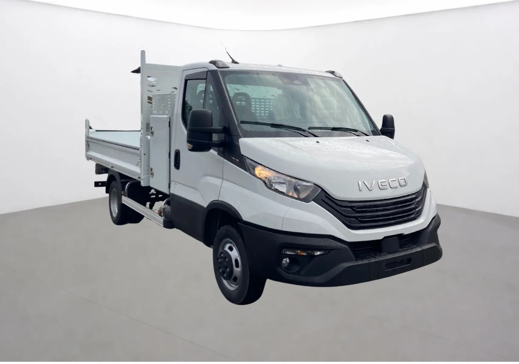 IVECO Daily Chassis Cabine blanc en 3/4 avant droit avec benne acier et coffre latéral visible.