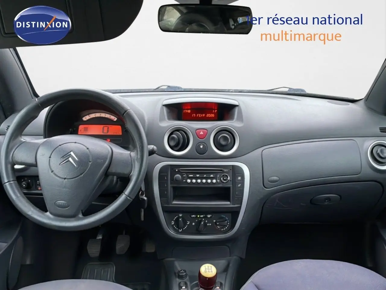 Vue intérieure du tableau de bord de la Citroën C3 Pluriel 2007, volant à gauche et levier de vitesse manuel ivoire.