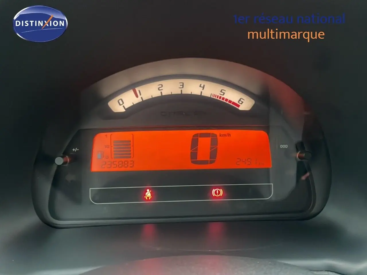 Tableau de bord numérique de Citroën C3 Pluriel 2007 avec affichage orange du compteur et compte-tours analogique.