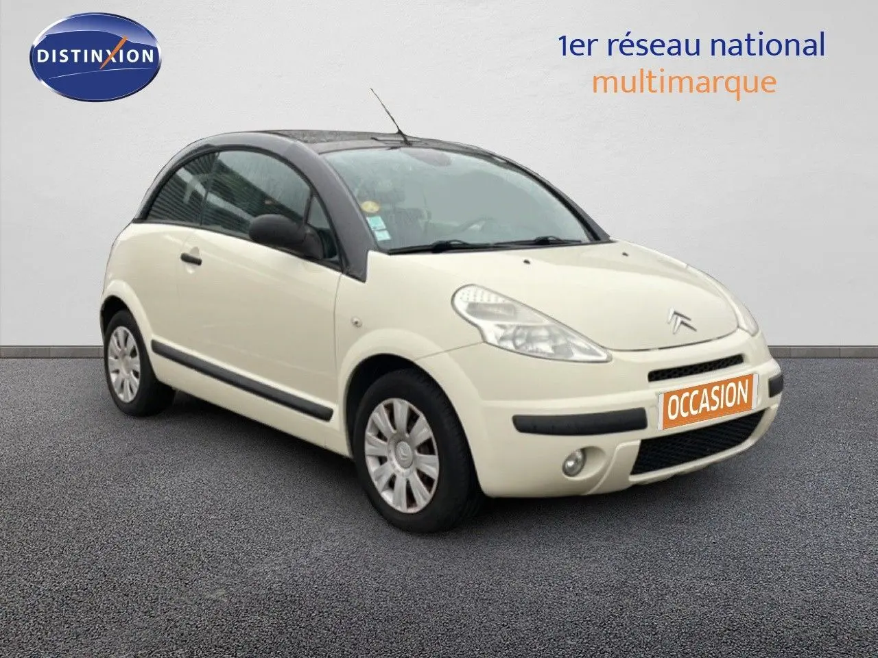 Citroën C3 Pluriel ivoire vue 3/4 avant droit avec toit noir et plaque "OCCASION" orange.