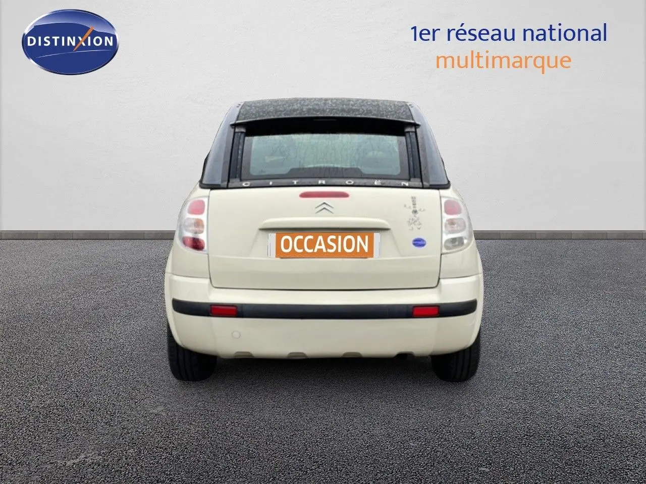 Vue arrière d'une Citroën C3 Pluriel ivoire de 2007 avec toit noir et plaque d'immatriculation orange "OCCASION".