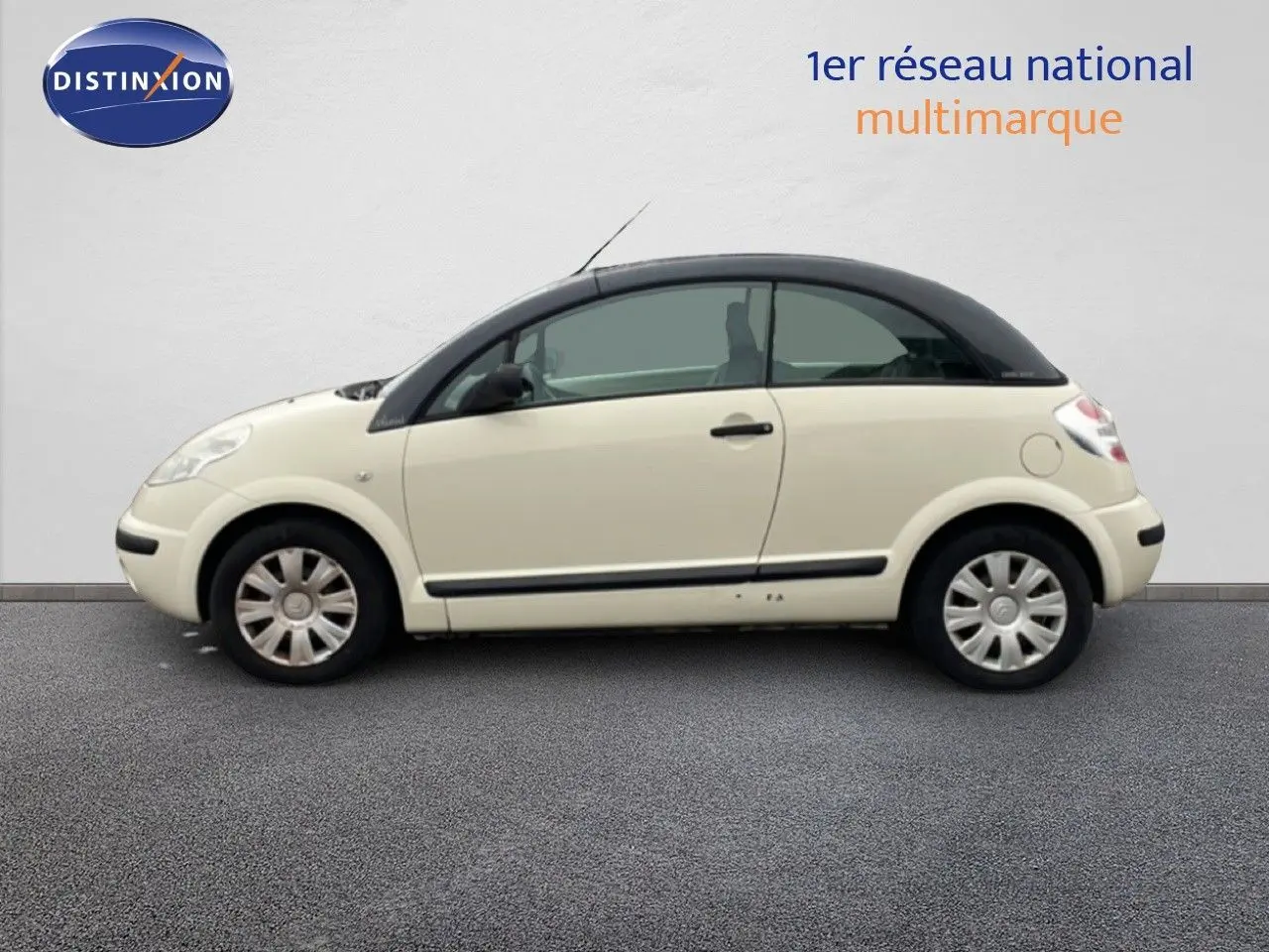 Profil droit d'une Citroën C3 Pluriel ivoire 2007 avec toit noir, roues acier et poignées noires.