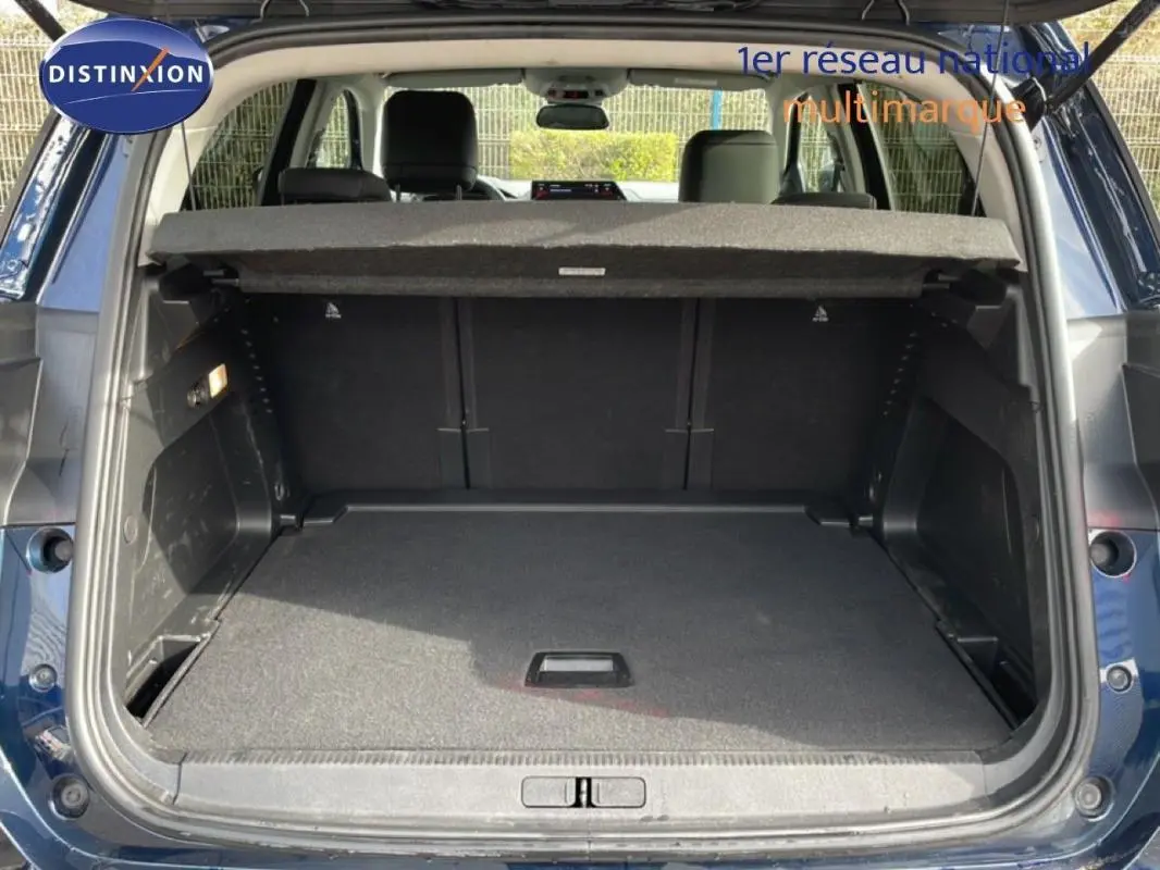 Coffre ouvert vu de l'arrière d'un Citroën C5 Aircross bleu 2024, montrant l'espace de chargement et la plage arrière.