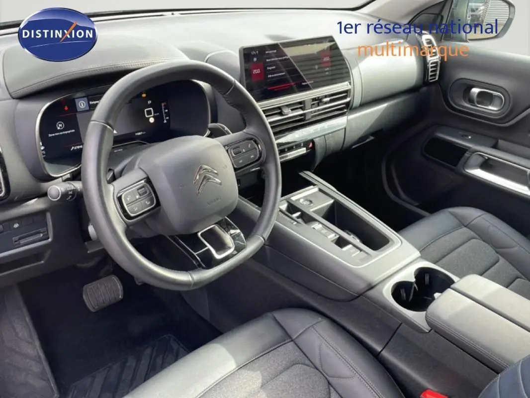 Vue intérieure côté conducteur du Citroën C5 Aircross 2024, avec volant cuir multifonctions et écran tactile central.
